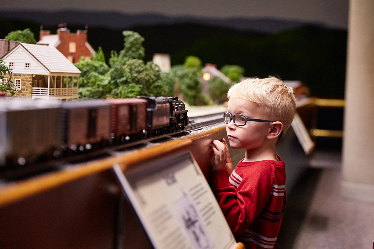Child looking at Miniature Railroad and Village
